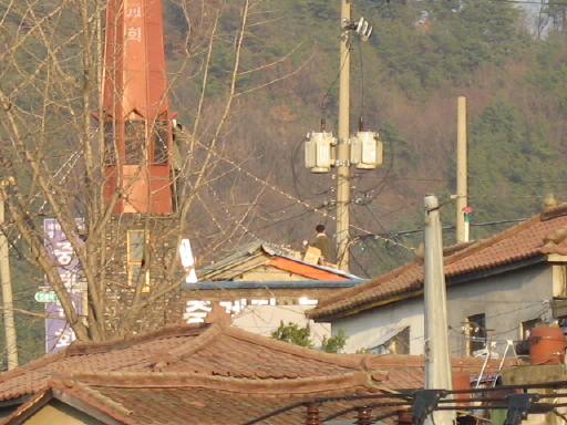 추위에도 불구하고 교회지붕에서 전등장식 작업중인 청년들 